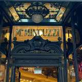 Ed eccoci ora davanti a un�altra elegantissima insegna realizzata su vetro trasparente. � quella di Mincuzzi, palazzo liberty edificato nel 1928 in Via Sparano per ospitare l�omonima ditta di abbigliamento